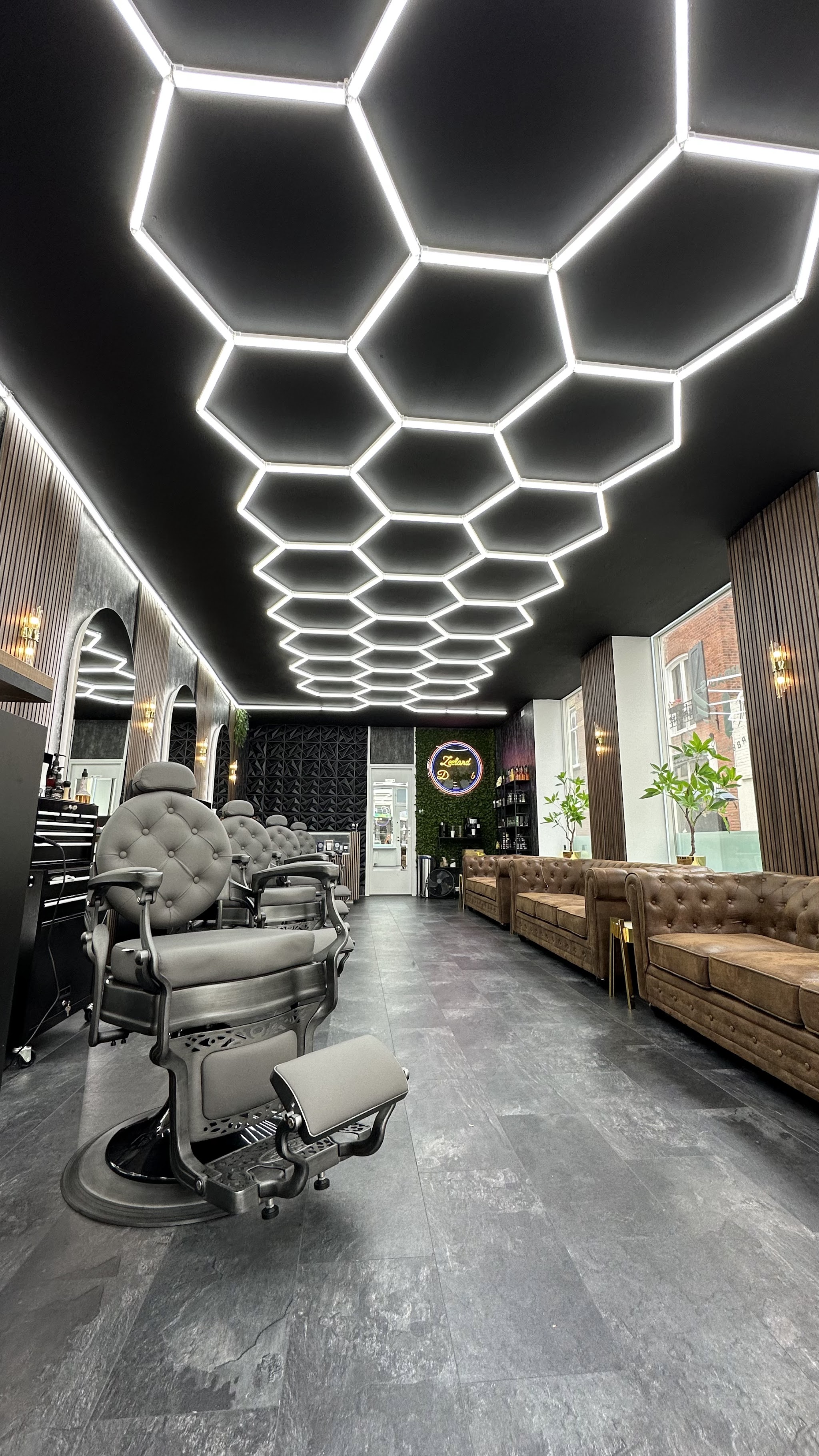 De zaak aan de Langeviele: het hexagonplafond van LED-licht, een vintage barbierstoel en leren chesterfield-banken