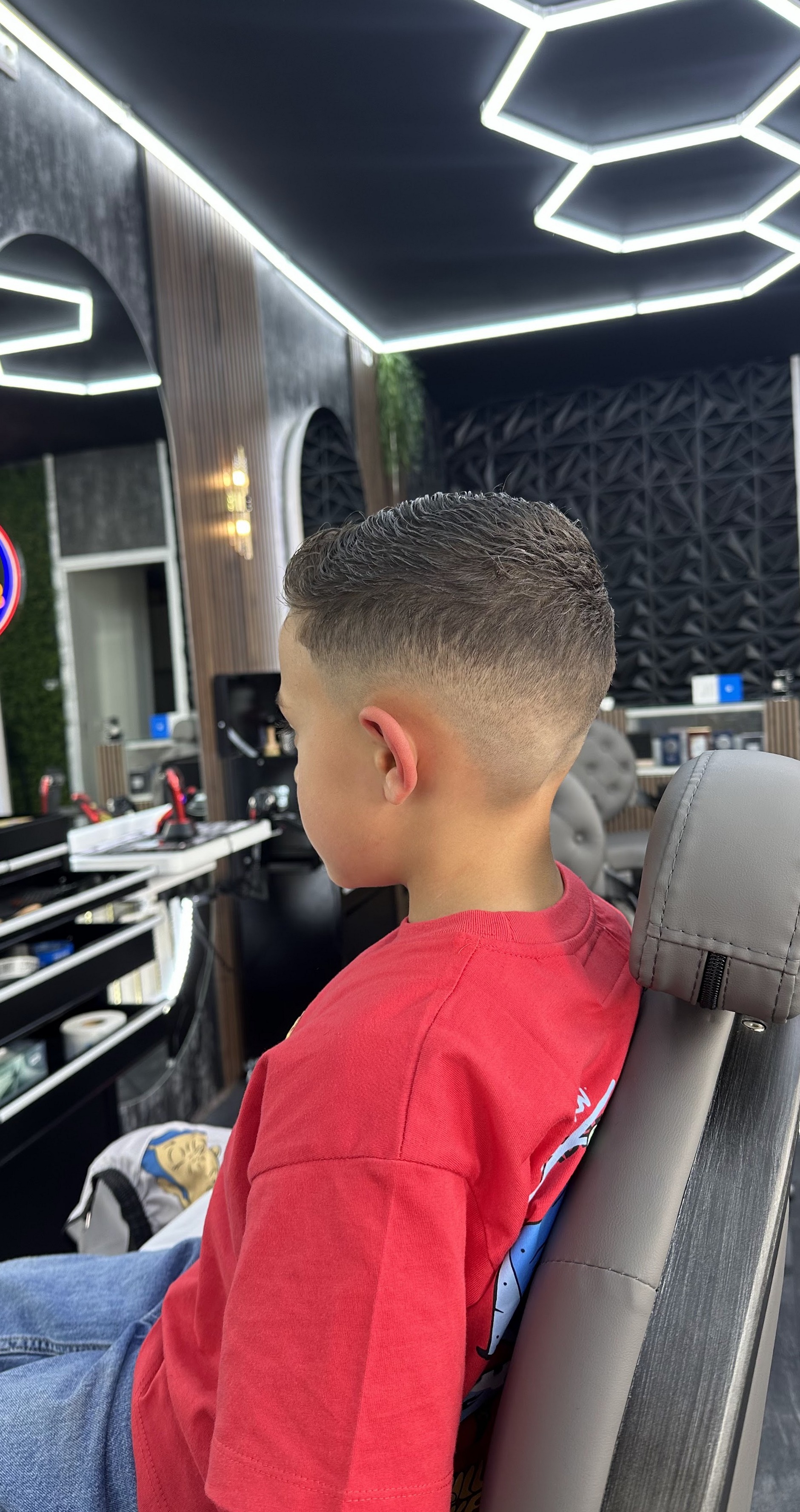Jonge klant met een verse fade in de barbierstoel